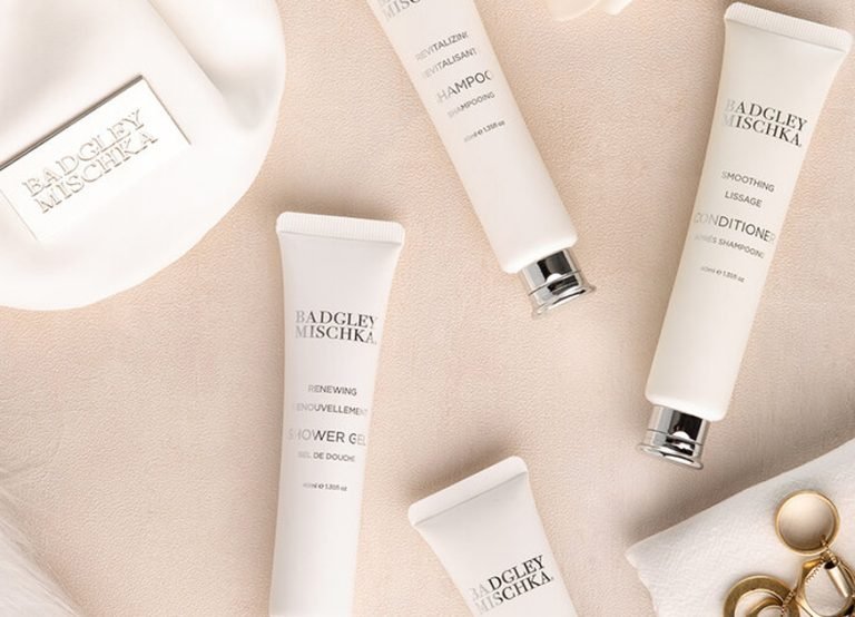 Badgley Mischka shower gel and conditioner tubes on cream fabric