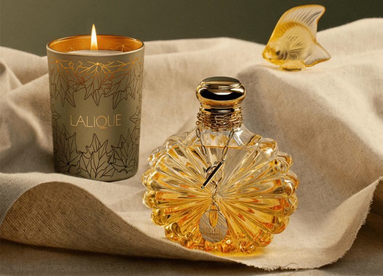 Lalique scented candle and amber crystal perfume bottle on linen