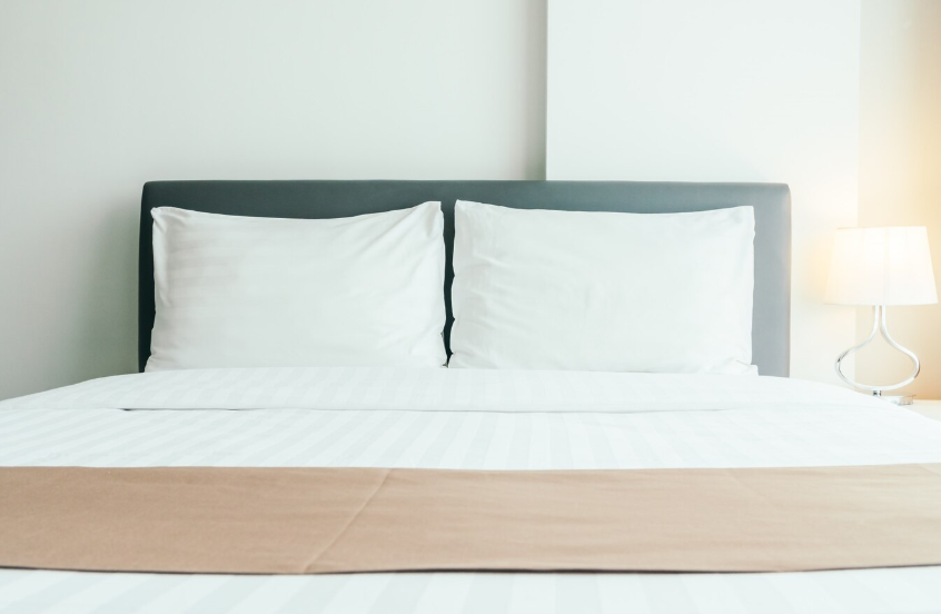 Hotel bed with white sheets and pillows