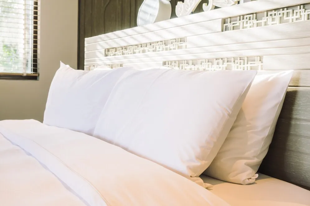 Made-up hotel bed with white pillows and linen