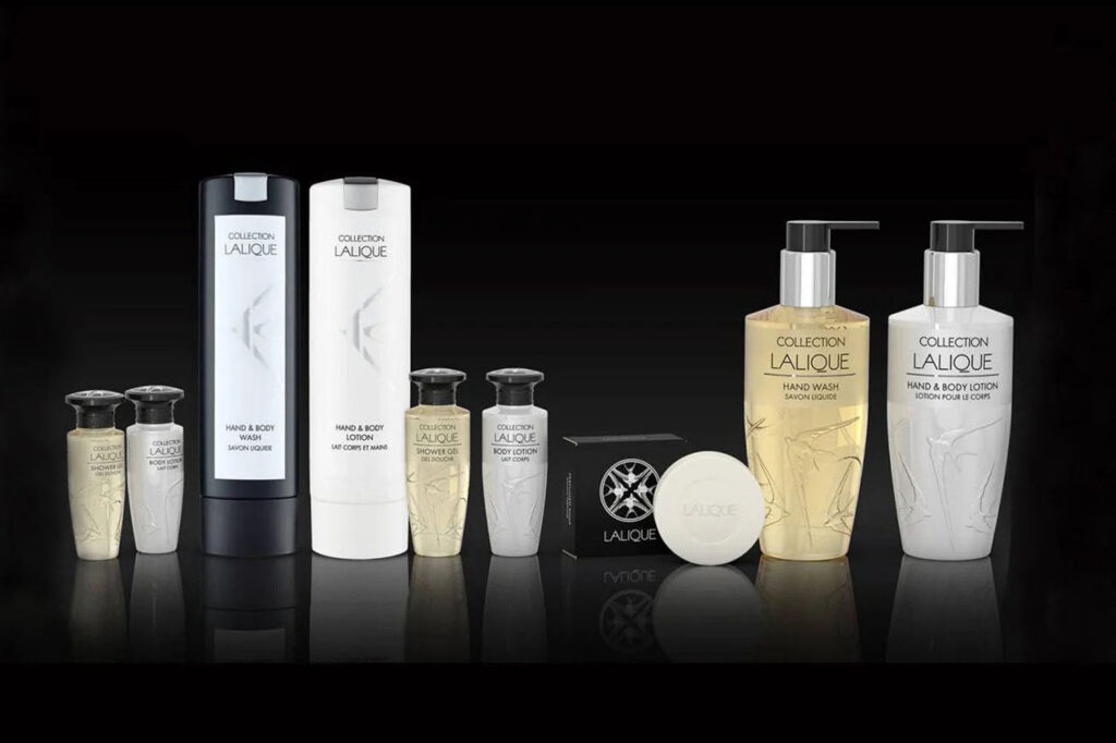 Black and white amenity bottles and soap on a dark background