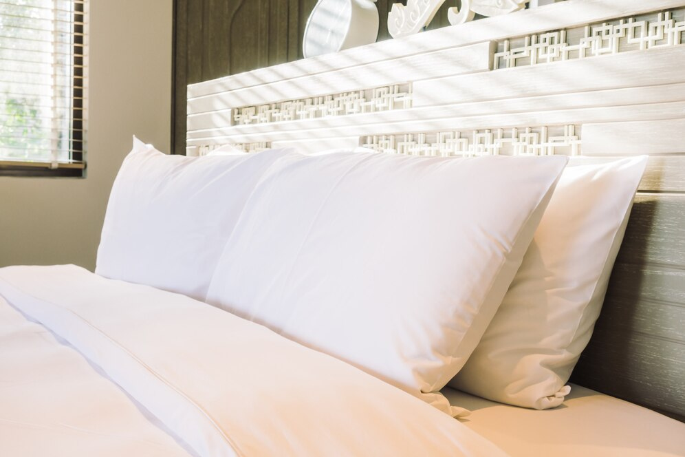 Hotel bed with white pillows and sheets