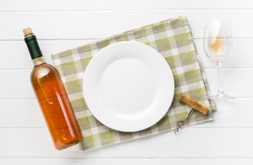Plate on a checked napkin with a wine bottle and glass